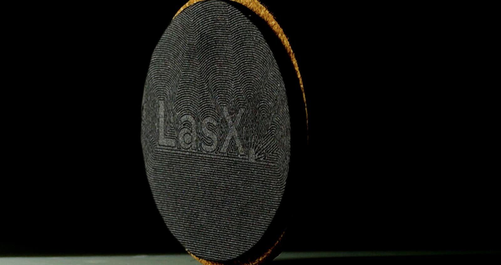 LasX logo laser-etched into the surface of a black coaster