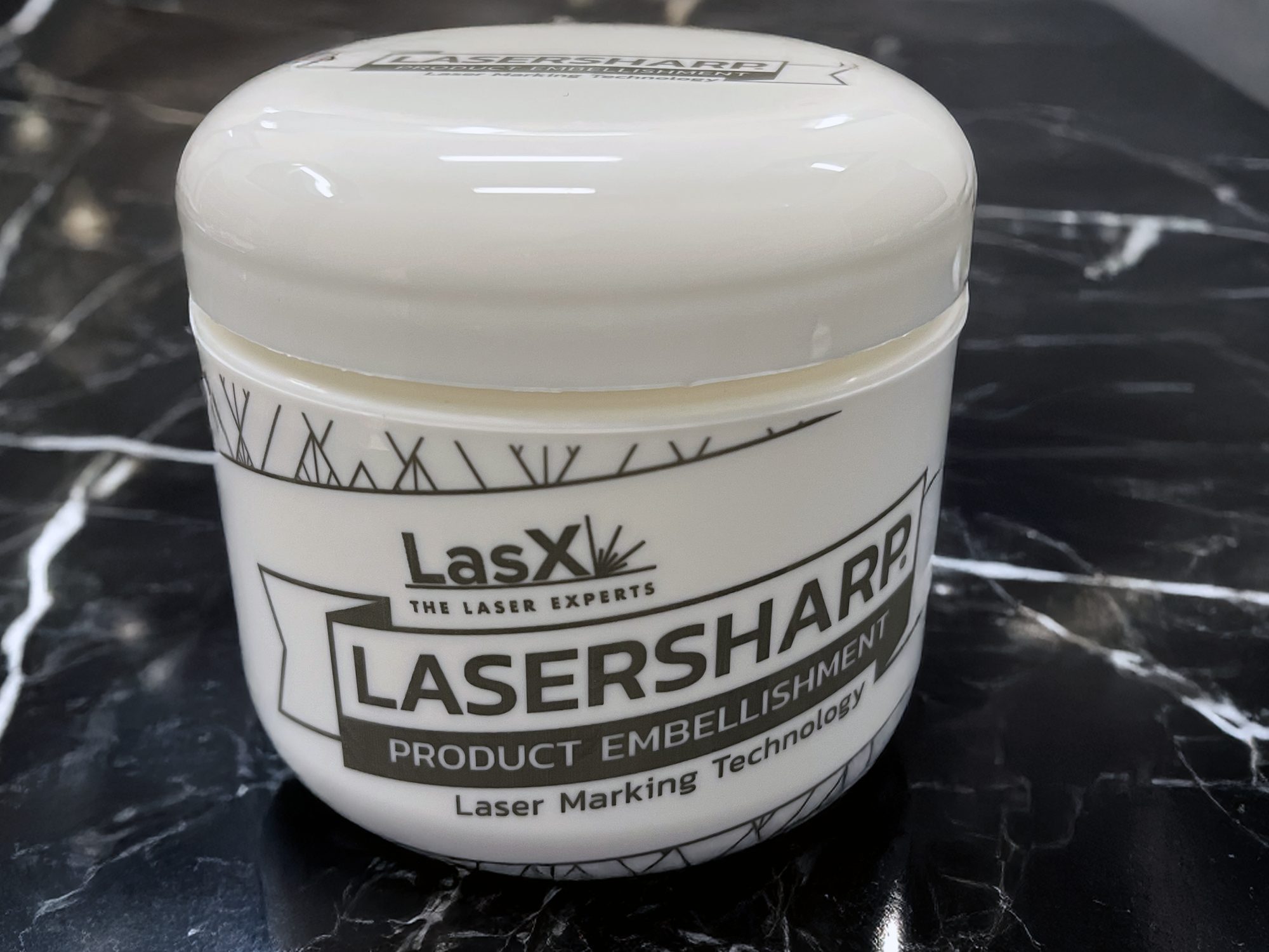 White jar with LaserSharp product-embellishment graphics laser-marked on the body and lid, no label or ink