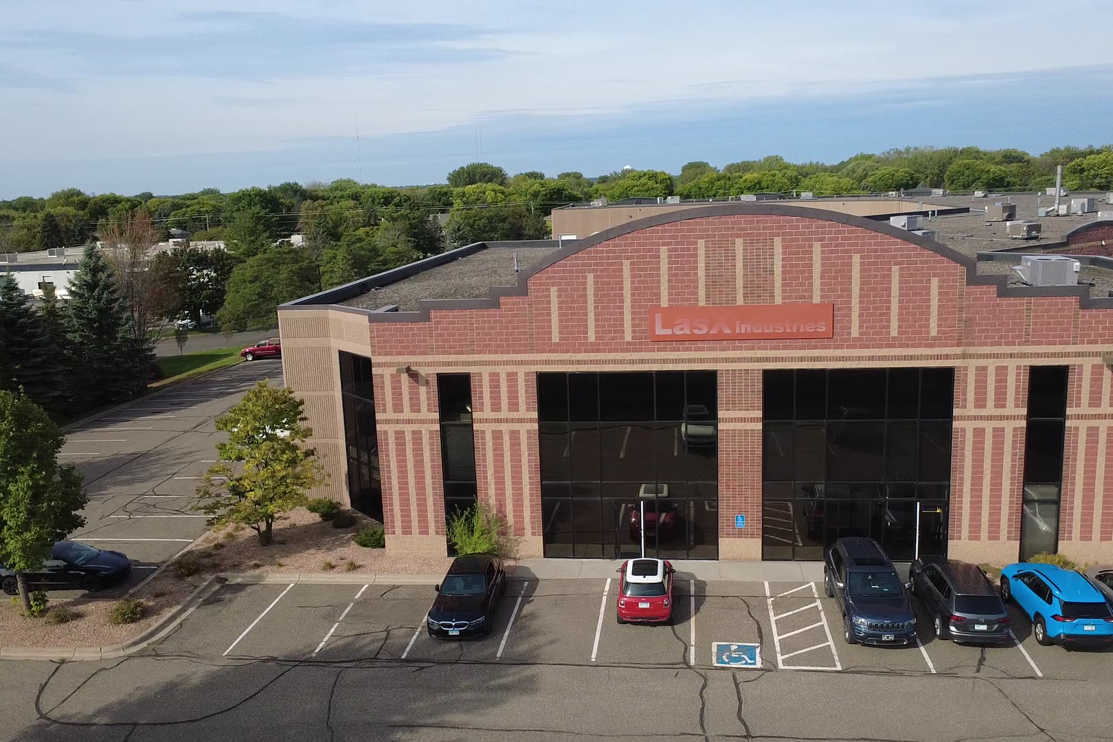 Aerial view of the brick LasX Industries building and its parking lot