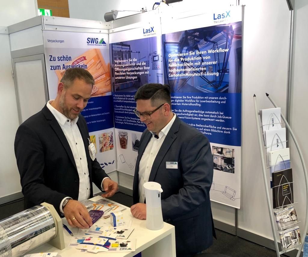 LasX team members with visitors at a trade-show stand