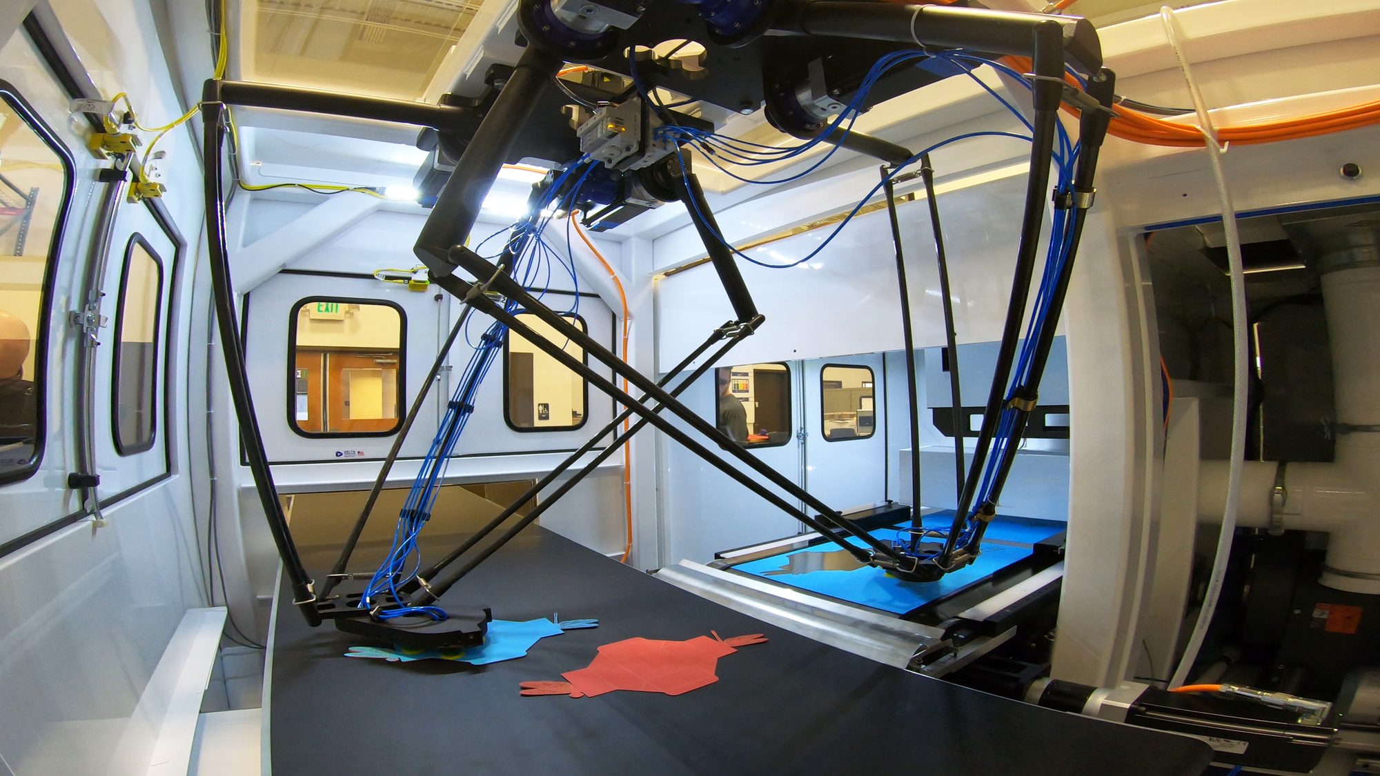 Delta robots picking laser-cut parts off the cutting bed in a LasX machine