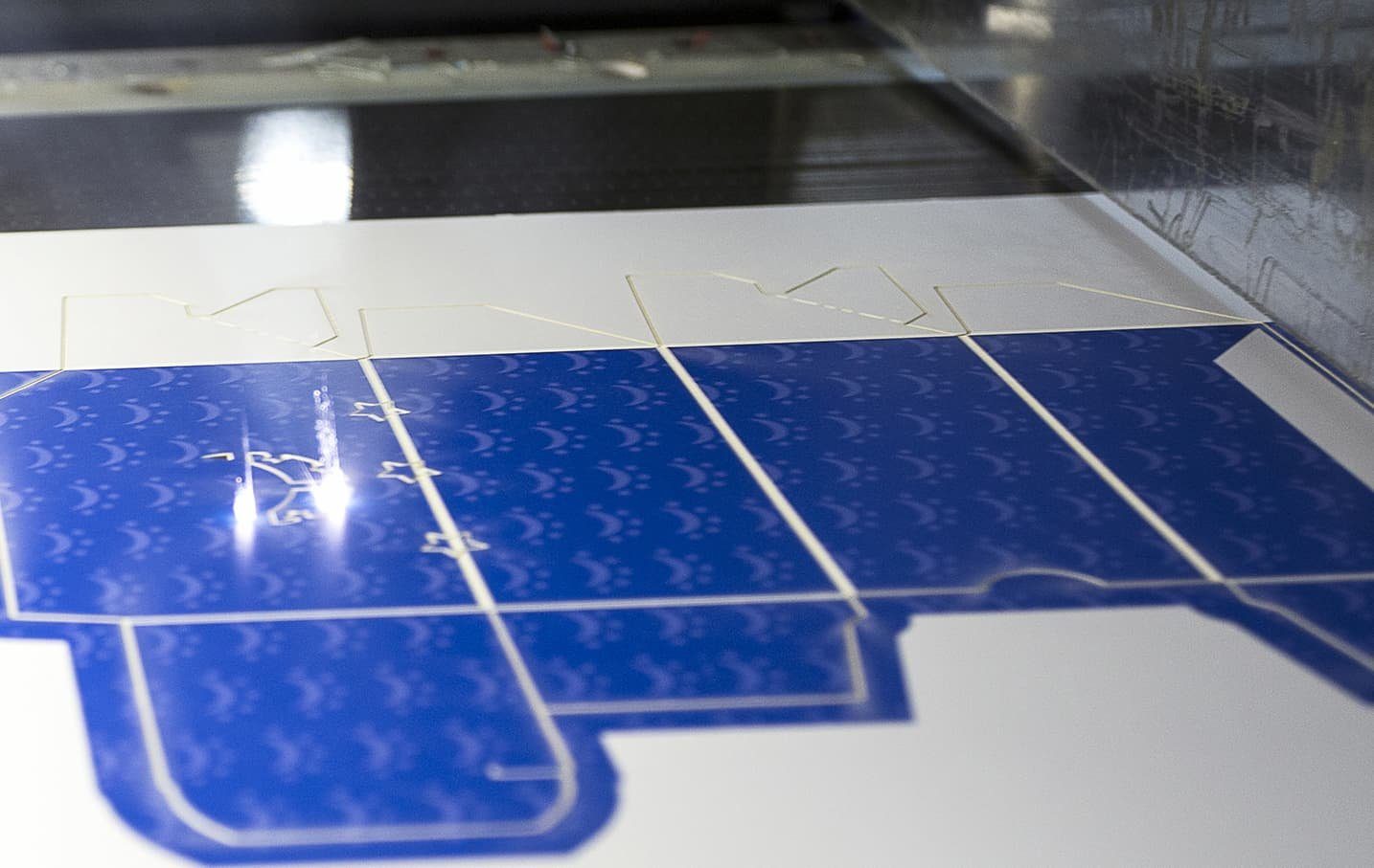 Stack of laser-cut blue carton sheets