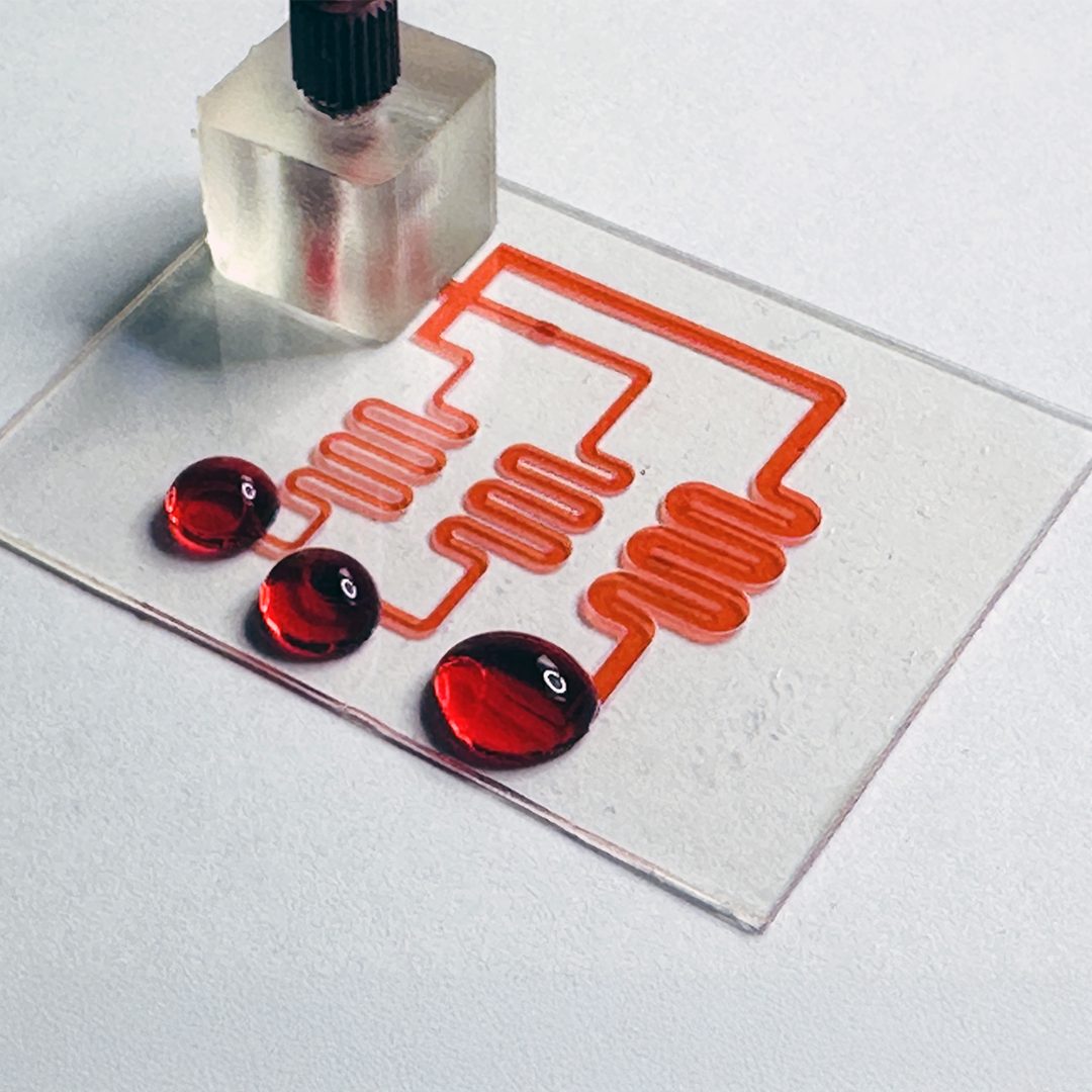 Microfluidic chip with red fluid in serpentine channels
