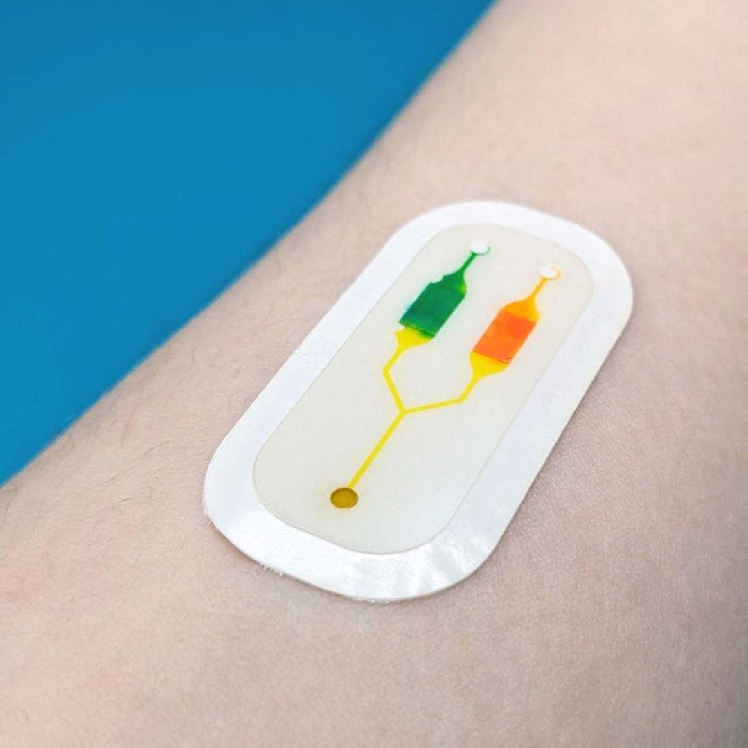 Wearable microfluidic patch on skin — laser-cut skin-safe adhesive, fluidic channels, and laminated layers