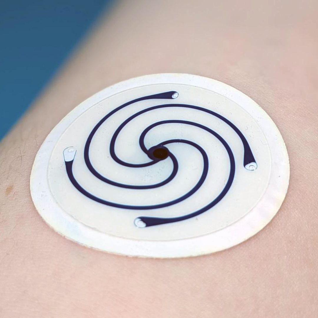 Round wearable electrode with spiral fluid channels, worn on the skin