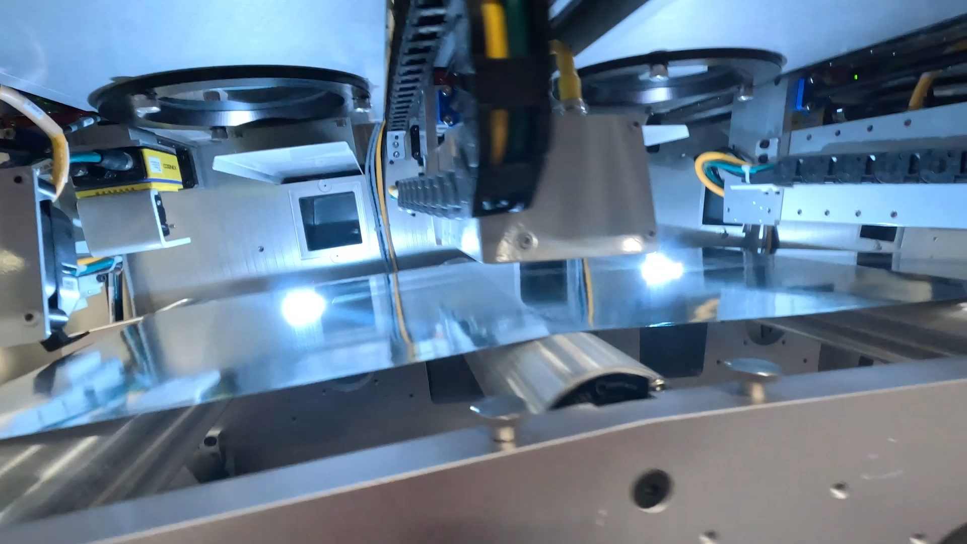 LaserSharp processing modules and vision sensor over a bright metal foil web inside a roll-to-roll converting machine