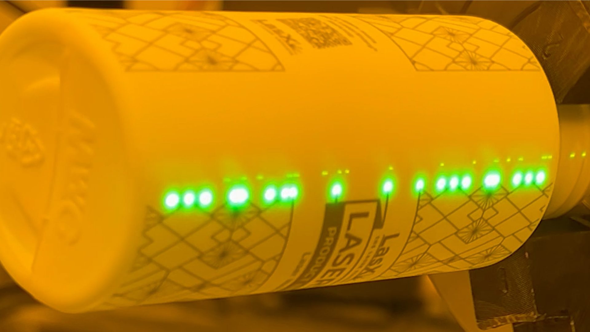 Green laser marking a label-replacement design onto a bottle