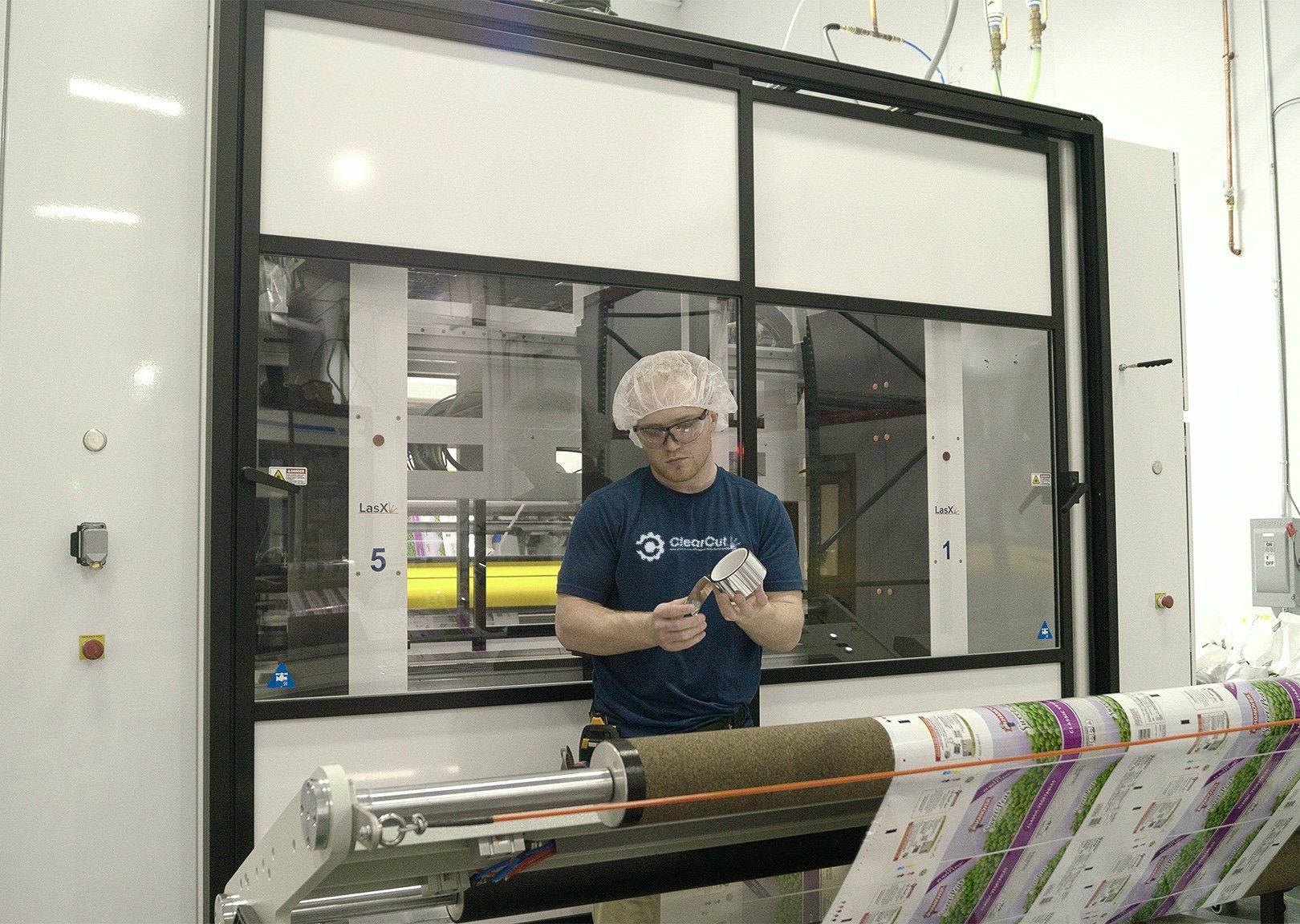 Service technician in a ClearCut shirt working on a module part at a LasX machine