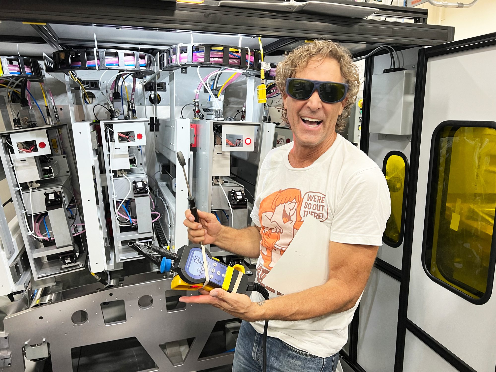 Service technician inside a machine enclosure, wearing laser safety glasses